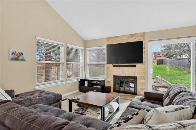 a living room with furniture a flat screen tv and a fireplace