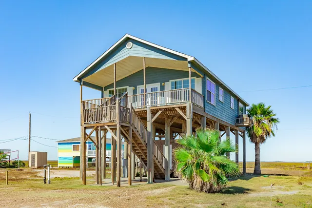 a front view of a house with a palm tree