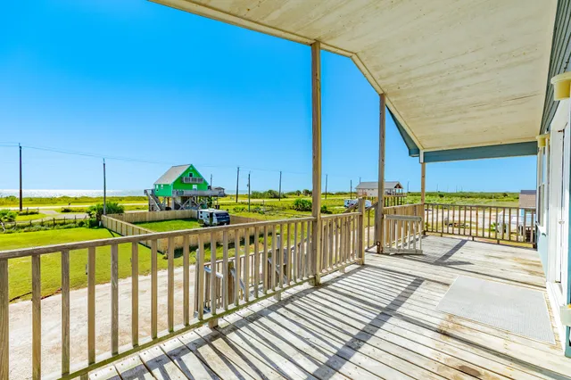 a view of a balcony with wooden floor and fence