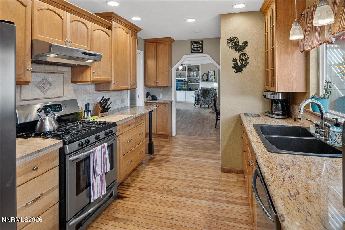 1831 North Division Street Carson City, NV 89703 - Photo 13 of 35 a kitchen with stainless steel appliances granite countertop a sink a stove and a wooden floors