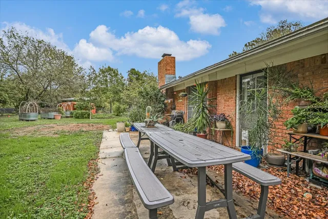 a view of a patio with table and chairs and potted plants