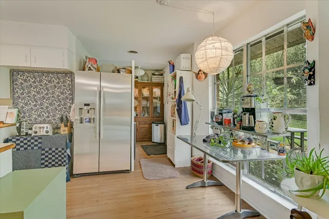 a very nice looking open dining room with kitchen island stainless steel appliances furnished patio and a table