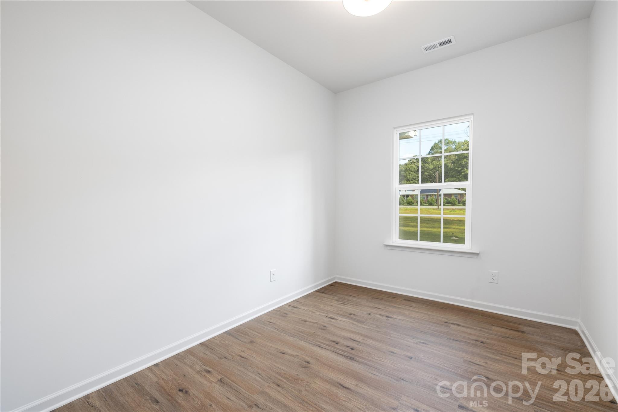 1422 Summerville Road Charlotte, NC 28214 - Photo 10 of 24 an empty room with wooden floor and windows