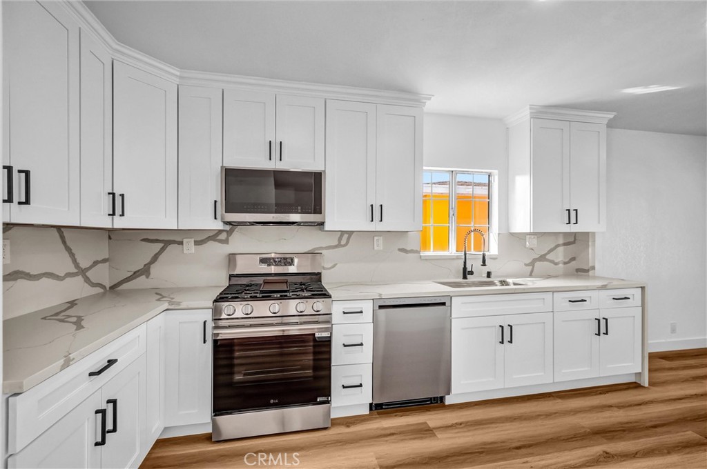 1200 South Castlegate Avenue Compton, CA 90221 - Photo 12 of 39 a kitchen with stainless steel appliances a stove a sink and a microwave