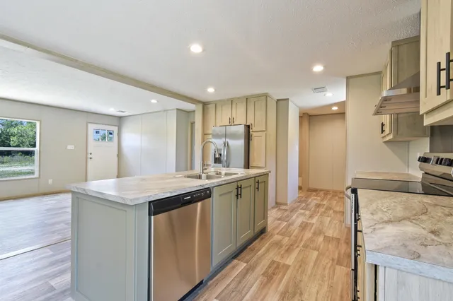 a kitchen with stainless steel appliances granite countertop a sink stove and refrigerator