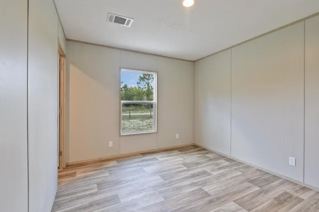 wooden floor in an empty room with a window