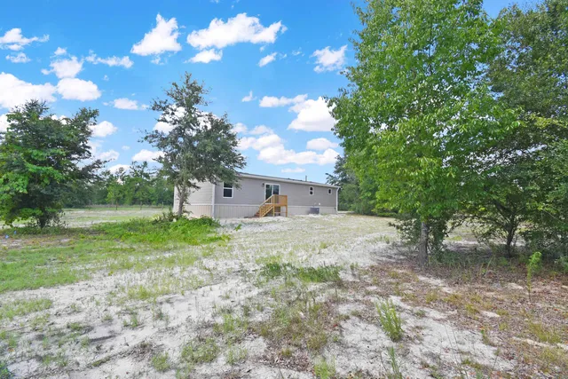 a view of a house with a backyard