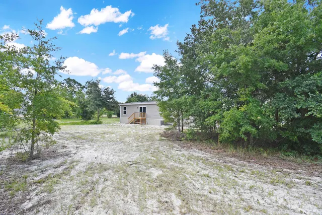 a view of a house with a backyard