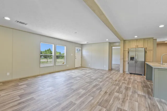 a view of a big room with wooden floor and a window