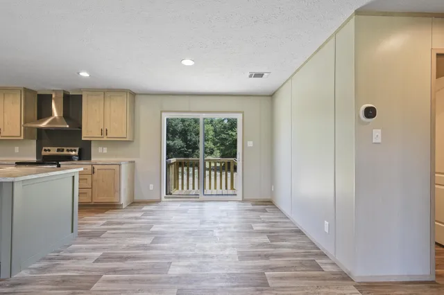 a view of a kitchen with a sink and dishwasher a refrigerator with wooden floor