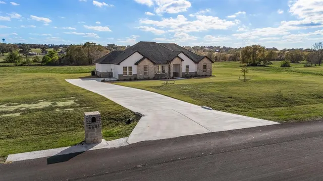 an aerial view of a house with big yard