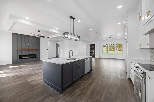 a large kitchen with stainless steel appliances kitchen island a large counter top and a wooden floors