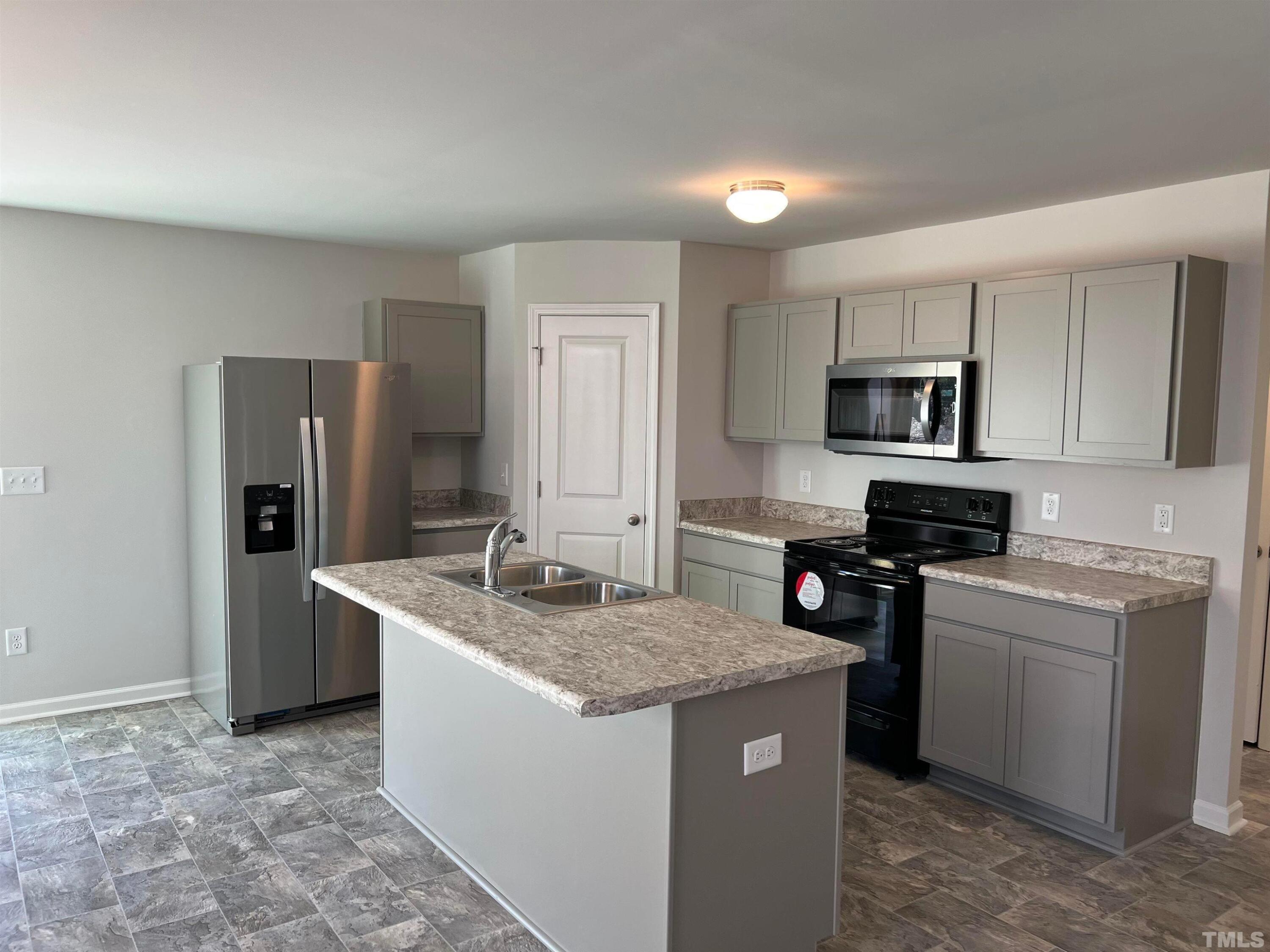 179 Maple Tree Lane Clayton, NC 27527 - Photo 2 of 18 a kitchen with a sink stove and refrigerator