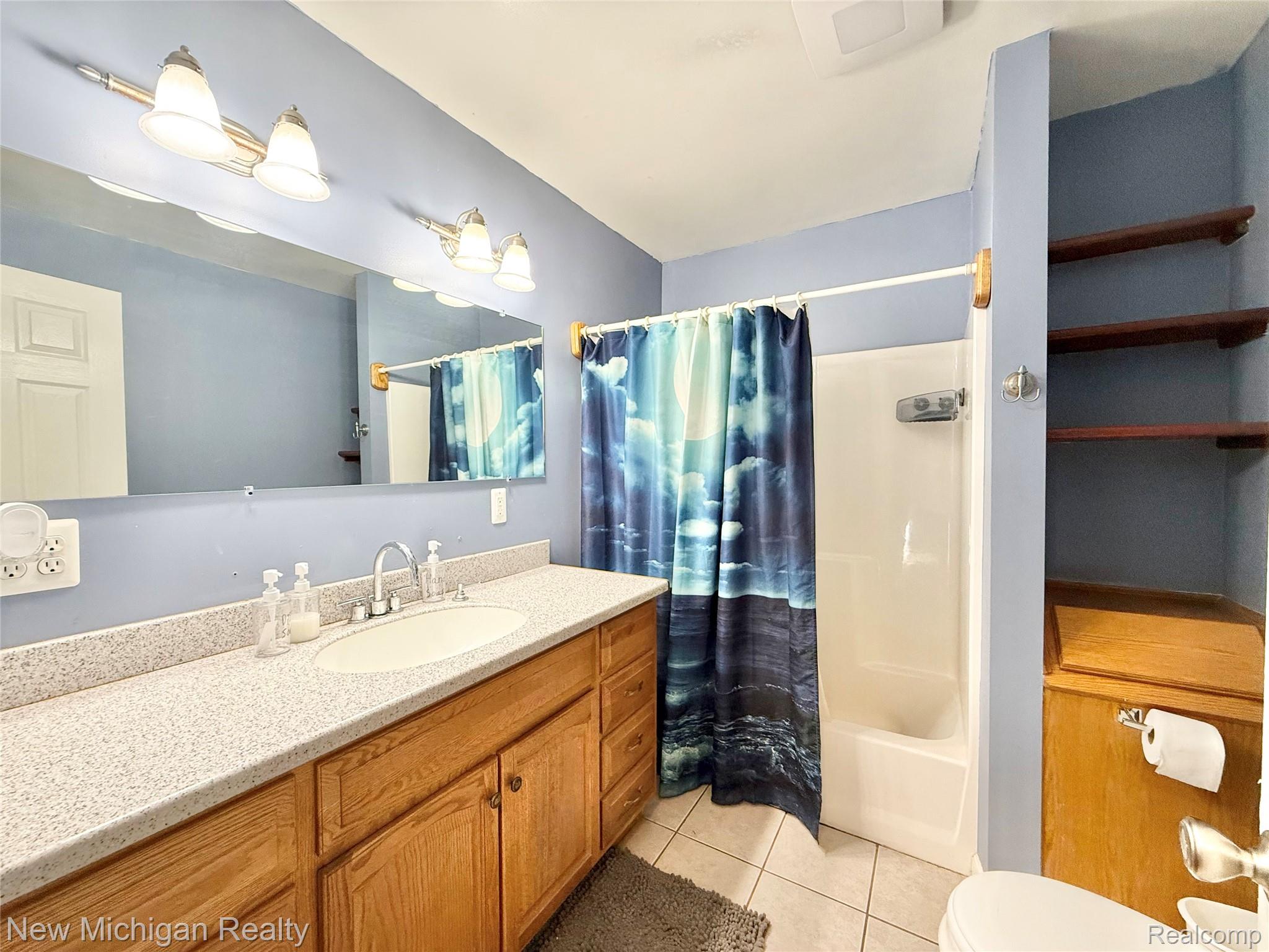 5288 Torrey Road Flint, MI 48507 - Photo 12 of 41 Bathroom with vanity, shower / bath combo with shower curtain, and light tile patterned flooring