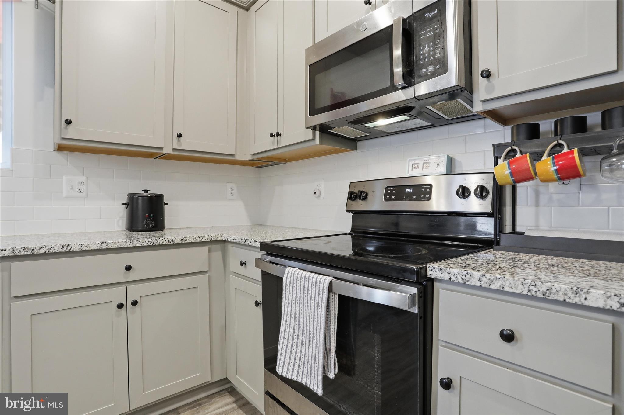 76 Diving Scaup Road Hedgesville, WV 25427 - Photo 9 of 48 a kitchen with stainless steel appliances granite countertop a stove microwave and cabinets