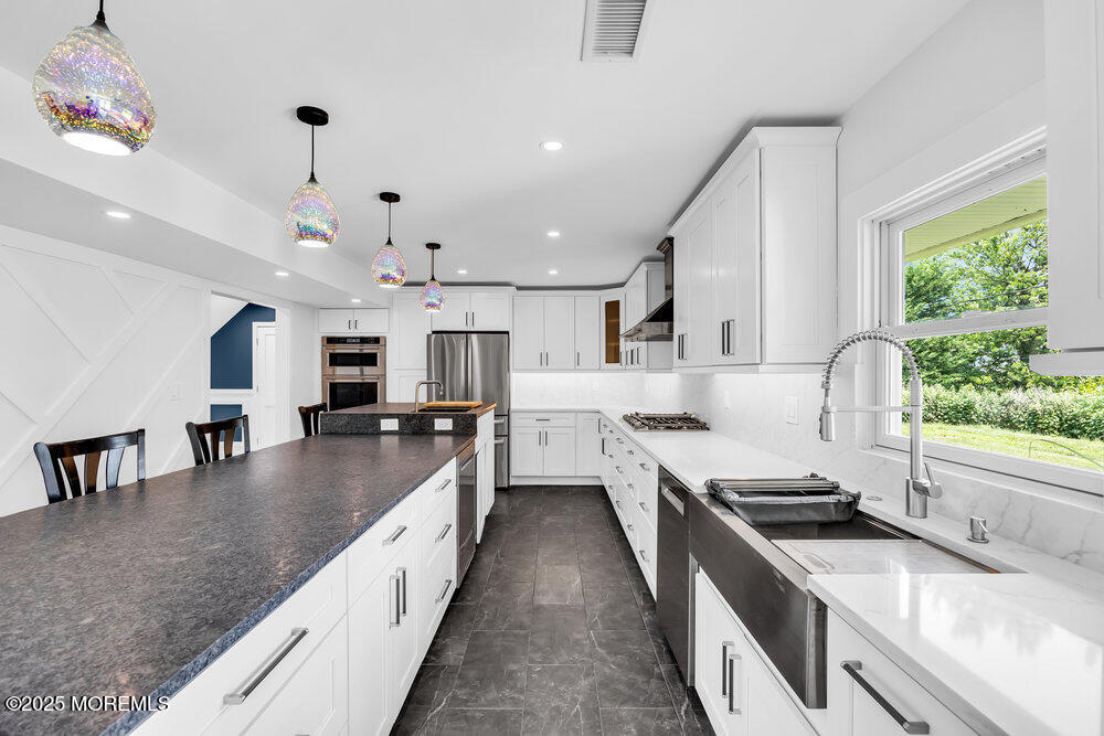 590 Lloyd Road Aberdeen, NJ 07747 - Photo 54 of 71 a large kitchen with stainless steel appliances granite countertop a lot of counter space and a sink