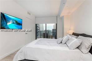 45 Southwest 9th Street, Unit 1701 Miami, FL 33130 - Photo 16 of 24 a bedroom with a large bed and a flat tv screen on dresser