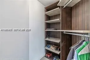 a view of walk in closet with clothes and shoes