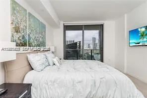 a large bed sitting in a bedroom next to a window
