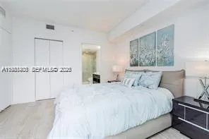 a spacious bedroom with a bed and a night stand