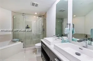 a bathroom with a double vanity sink toilet and shower