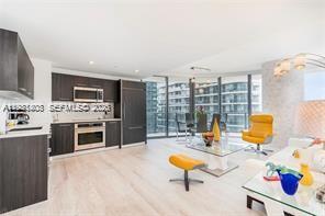 45 Southwest 9th Street, Unit 1701 Miami, FL 33130 - Photo 3 of 24 a living room with furniture a fireplace and a flat screen tv