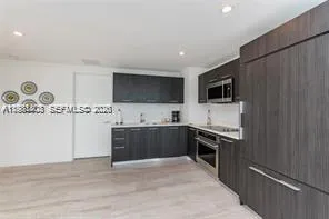 a large kitchen with a stove top oven and sink