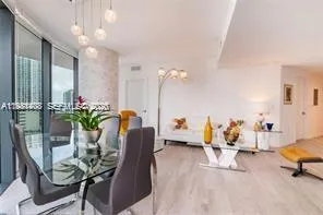 a living room with furniture flowerpot and a chandelier