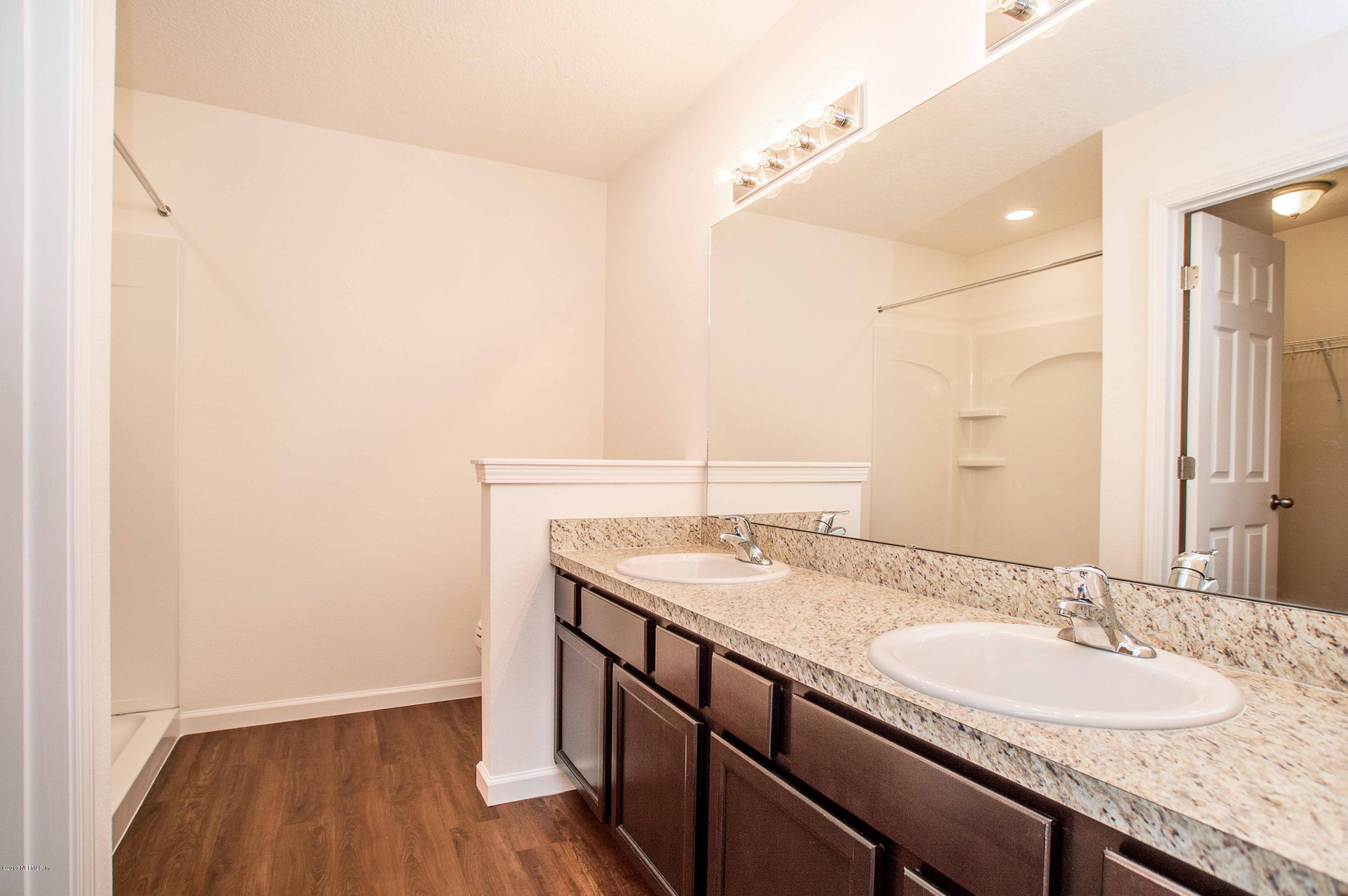 78263 Saddle Rock Road Yulee, FL 32097 - Photo 8 of 13 a bathroom with a granite countertop sink and a mirror