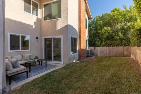 a view of an house with backyard and sitting area