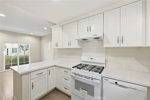 a kitchen with kitchen island white cabinets and stainless steel appliances