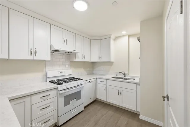 a kitchen with white cabinets and white appliances