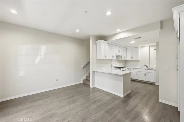 a kitchen with a sink cabinets and wooden floor