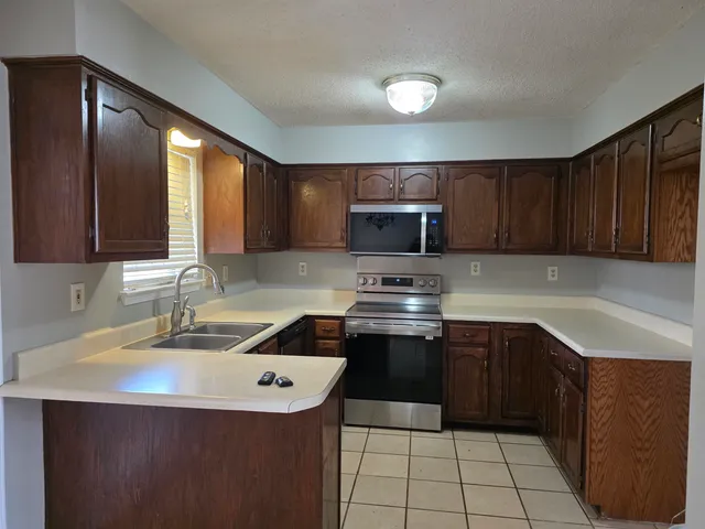 a kitchen with a sink a stove top oven and cabinets