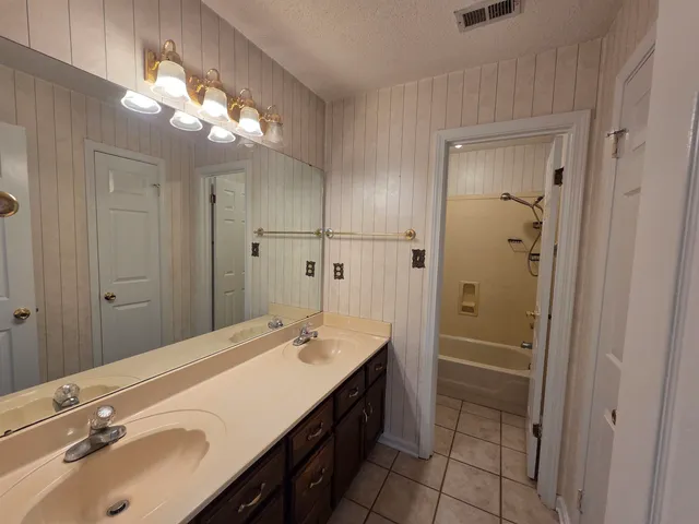 a bathroom with a double vanity sink mirror and shower