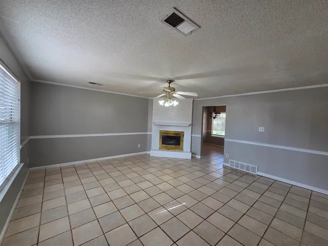an empty room with windows and fireplace