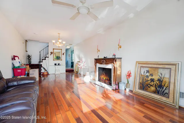 an empty room with fireplace wooden floor and chandelier