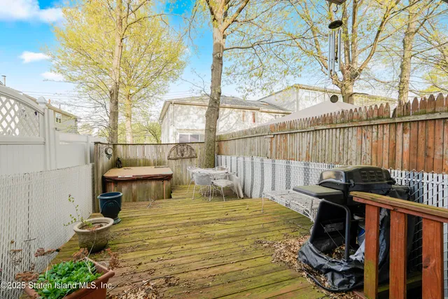 a view of a balcony with chairs and wooden fence