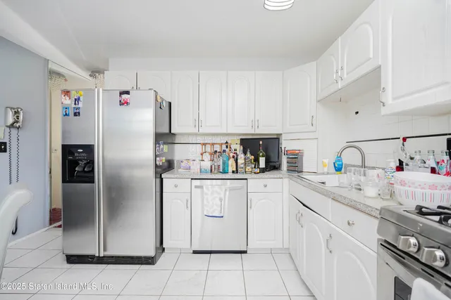 a kitchen with a refrigerator sink and cabinets