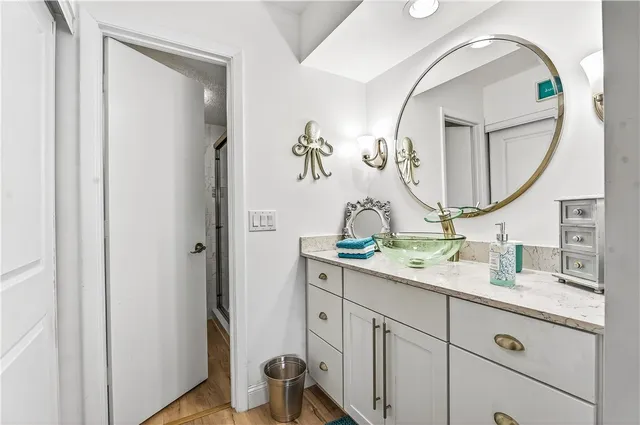 a bathroom with a granite countertop sink and a mirror