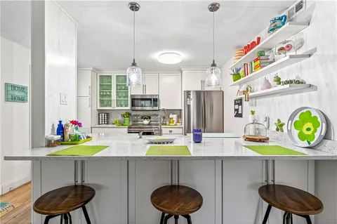 a kitchen with a refrigerator a stove and a wooden floor
