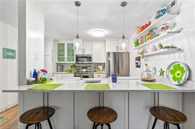a kitchen with a refrigerator a stove and a wooden floor