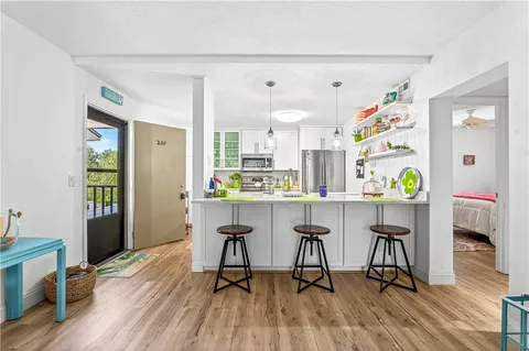 a kitchen with stainless steel appliances kitchen island a table and chairs in it