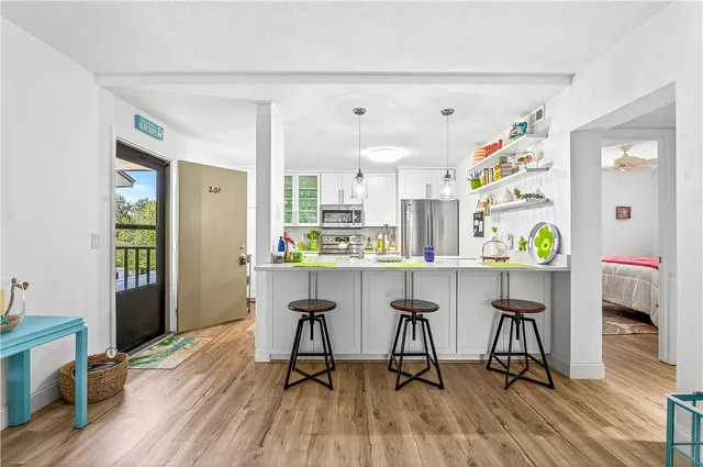 a kitchen with stainless steel appliances kitchen island a table and chairs in it