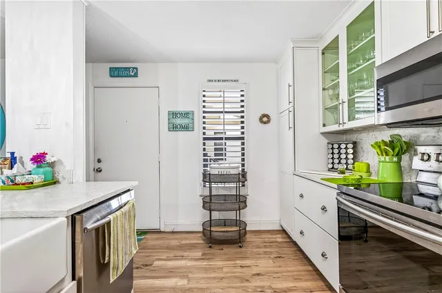 a kitchen with granite countertop lots of clutter and stainless steel appliances
