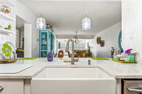 a dining room with kitchen island stainless steel appliances furniture a chandelier and a table