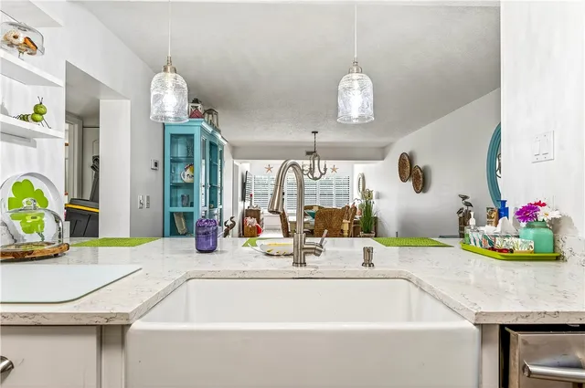a dining room with kitchen island stainless steel appliances furniture a chandelier and a table