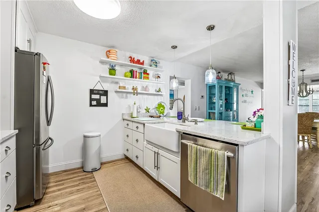 a kitchen with granite countertop a refrigerator and a sink