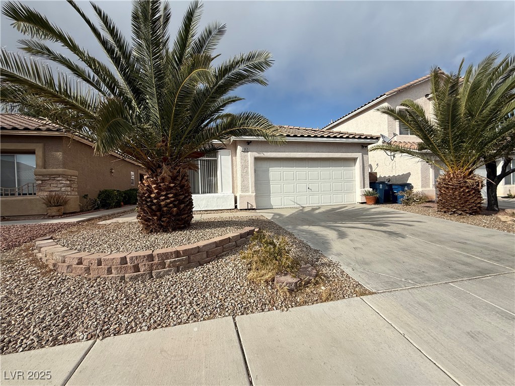 7062 Russell Ranch Avenue Las Vegas, NV 89113 - Photo 3 of 32 View of front of home with driveway, stucco siding, and an attached garage