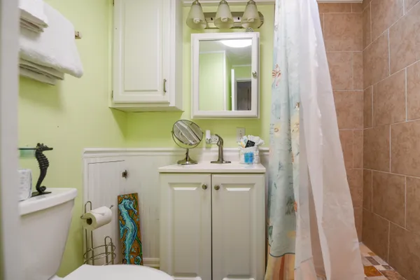 a bathroom with a sink a toilet and shower
